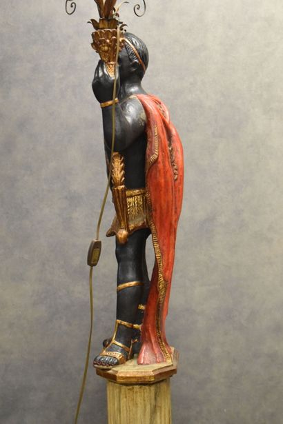 Man with a cape carrying a torch in carved...