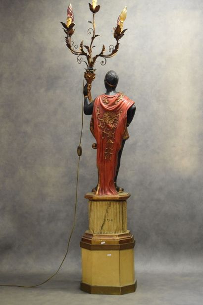 Man with a cape carrying a torch in carved...