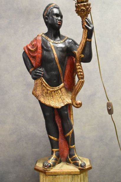 Man with a cape carrying a torch in carved...