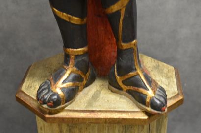 Man with a cape carrying a torch in carved...