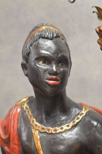 Man with a cape carrying a torch in carved...