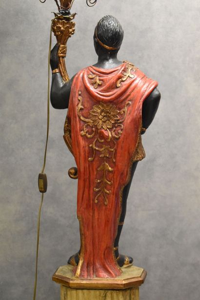 Man with a cape carrying a torch in carved...