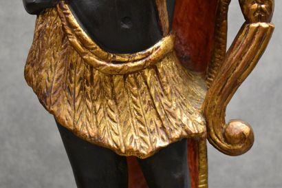 Man with a cape carrying a torch in carved...