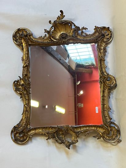 Un miroir doré à décor rocaille. H89xL67cm...