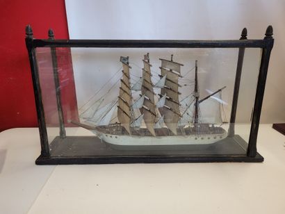Une maquette de voilier sous vitrine en bois...