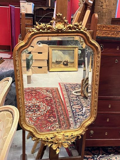 Un miroir biseauté doré à décor coquille....