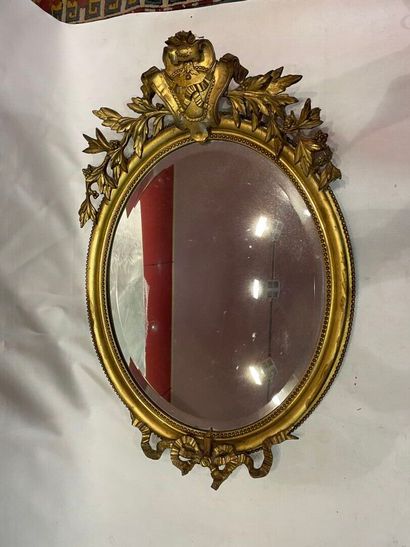 Miroir biseauté, encadrement ovale doré à...
