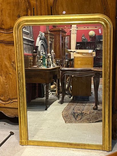 Un miroir de cheminé doré de style Louis...