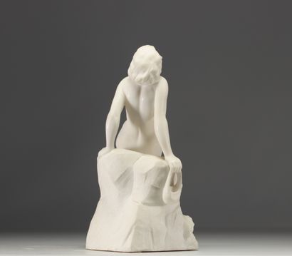 Jeune femme nue assise sur un rocher se lovant...