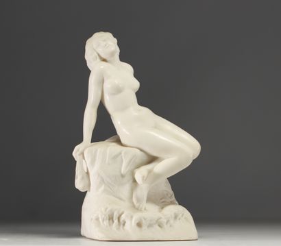 Jeune femme nue assise sur un rocher se lovant...