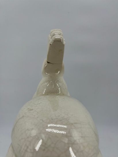 LEMANCEAU. Paon en faïence blanche craquelée....