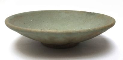 A round glazed terracotta bowl with a celadon...