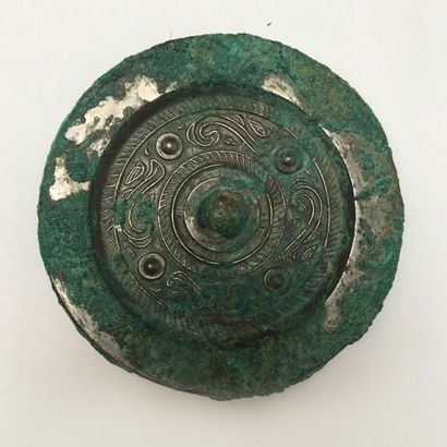 Bronze mirror with green patina, decorated...