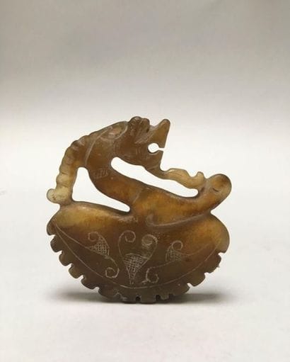 Amber-coloured jade dragon/goat plaque depicting...