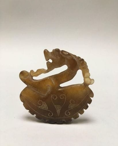 Amber-coloured jade dragon/goat plaque depicting...
