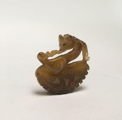 Amber-coloured jade dragon/goat plaque depicting...