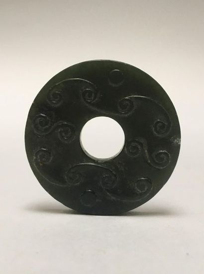 Small dark green jade BI disk. It is decorated...