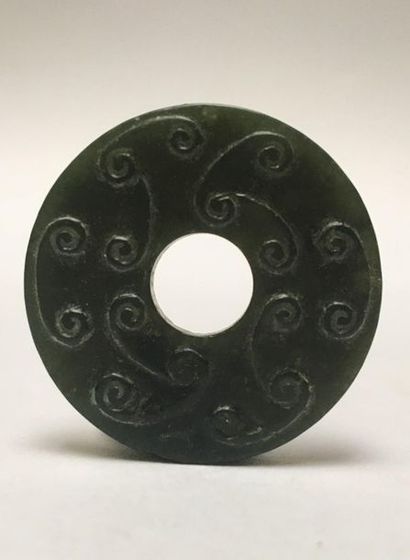 Small dark green jade BI disk. It is decorated...