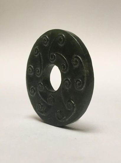 Small dark green jade BI disk. It is decorated...