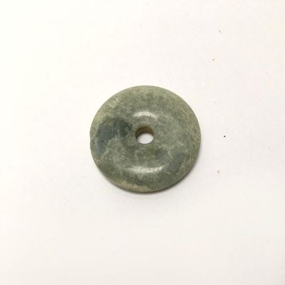 Nebulous green translucent chalcedony disc.

Undetermined...