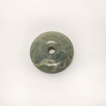 Nebulous green translucent chalcedony disc.

Undetermined...