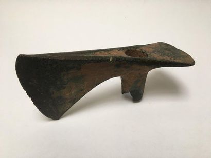 Double-bladed bronze axe with green patina...