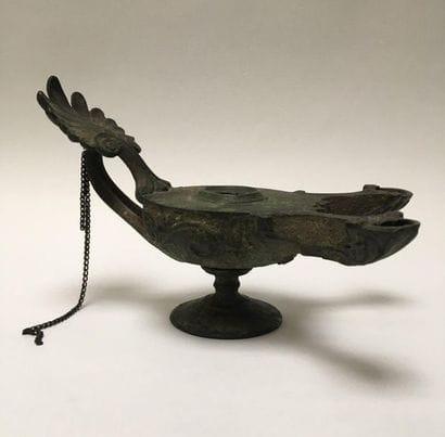 Bronze oil lamp with a green patina having...
