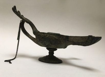 Bronze oil lamp with a green patina having...