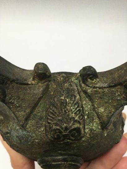 Bronze oil lamp with a green patina having...
