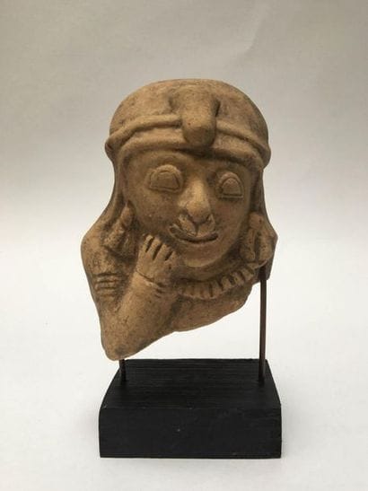 Richly adorned dignitary's head with a deformed...