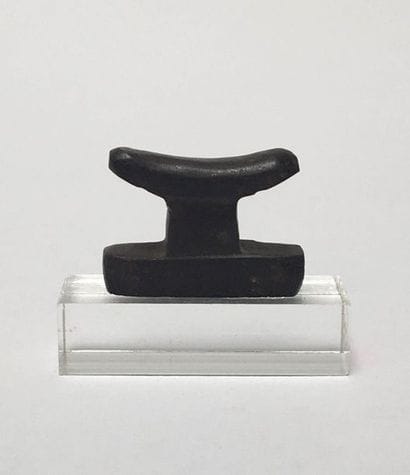 Hematite amulet representing a bedside table.

Egypt,...