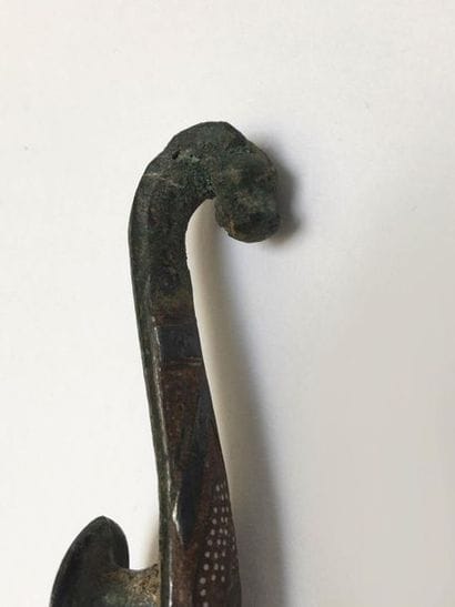 Bronze fibula inlaid with a semi of silver...