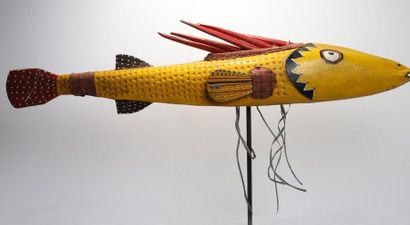 Puppet presenting a brightly coloured fish.

Polychrome...