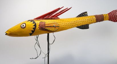 Puppet presenting a brightly coloured fish.

Polychrome...