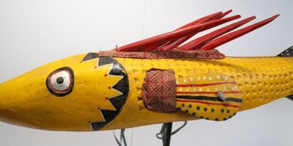 Puppet presenting a brightly coloured fish.

Polychrome...