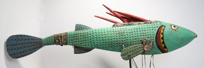 Puppet presenting a brightly coloured fish.

Polychrome...