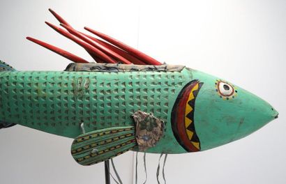Puppet presenting a brightly coloured fish.

Polychrome...