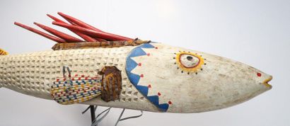 Puppet presenting a brightly coloured fish.

Polychrome...