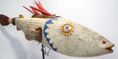 Puppet presenting a brightly coloured fish.

Polychrome...