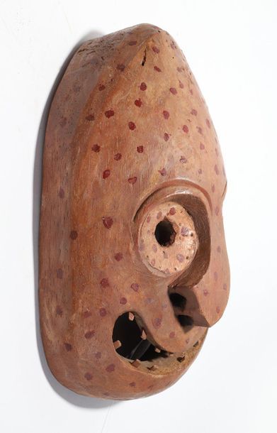 Decorative mask with a deformed face 
 
Wood,...