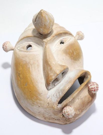 Decorative mask with a deformed face 
 
Wood,...