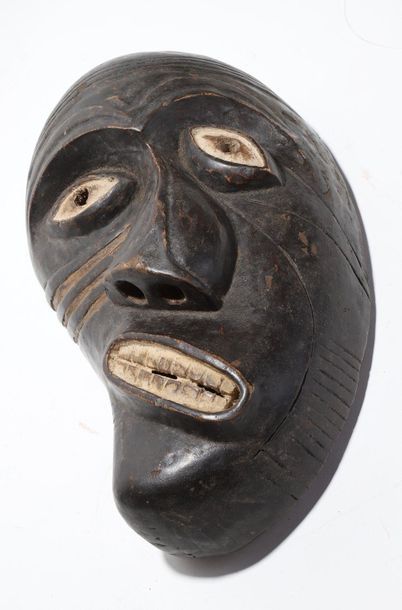 Decorative mask with a deformed face 
 
Wood...