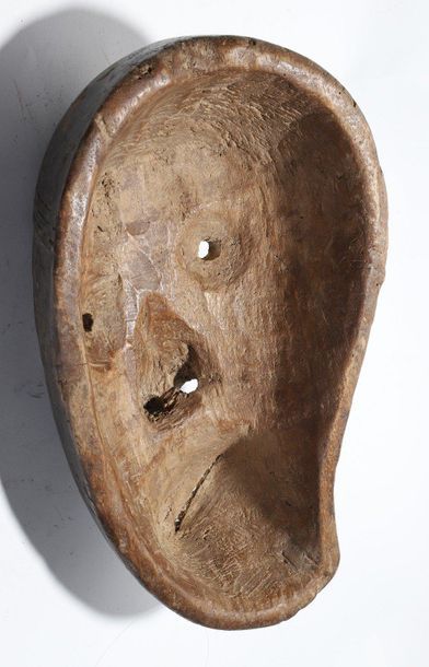 Decorative mask with a deformed face 
 
Wood...