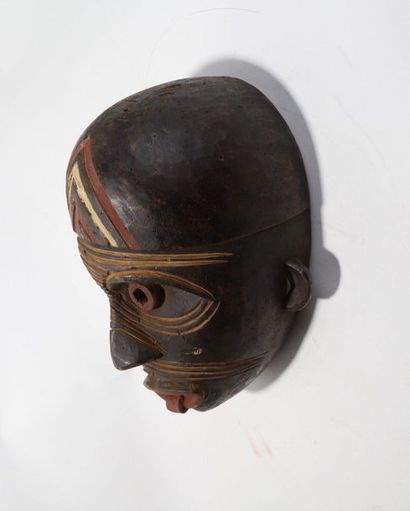 Decorative mask with a deformed face 
 
Wood...