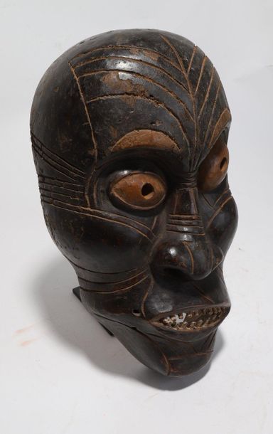 Decorative mask with a deformed face 
 
Wood...