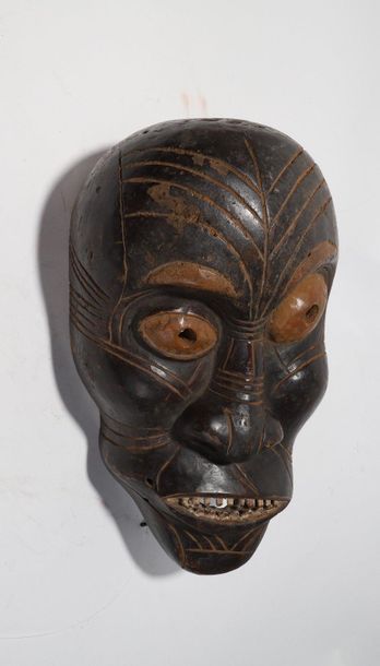Decorative mask with a deformed face 
 
Wood...