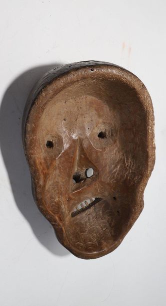 Decorative mask with a deformed face 
 
Wood...