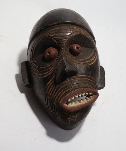 Decorative mask with a deformed face 
 
Wood...