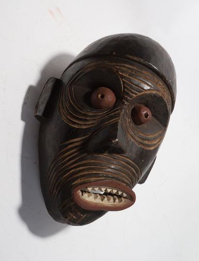Decorative mask with a deformed face 
 
Wood...