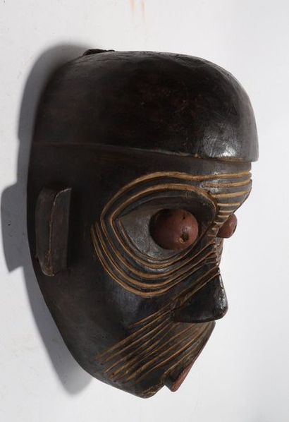 Decorative mask with a deformed face 
 
Wood...